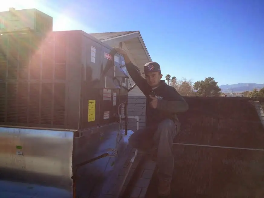 HVAC technician performing AC Tune-Up on a rooftop unit in La Mesa